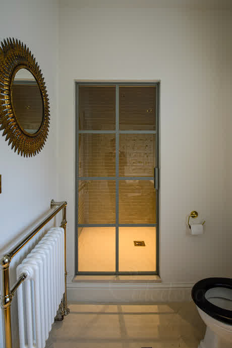 beige frame crittall style shower door in a bathroom