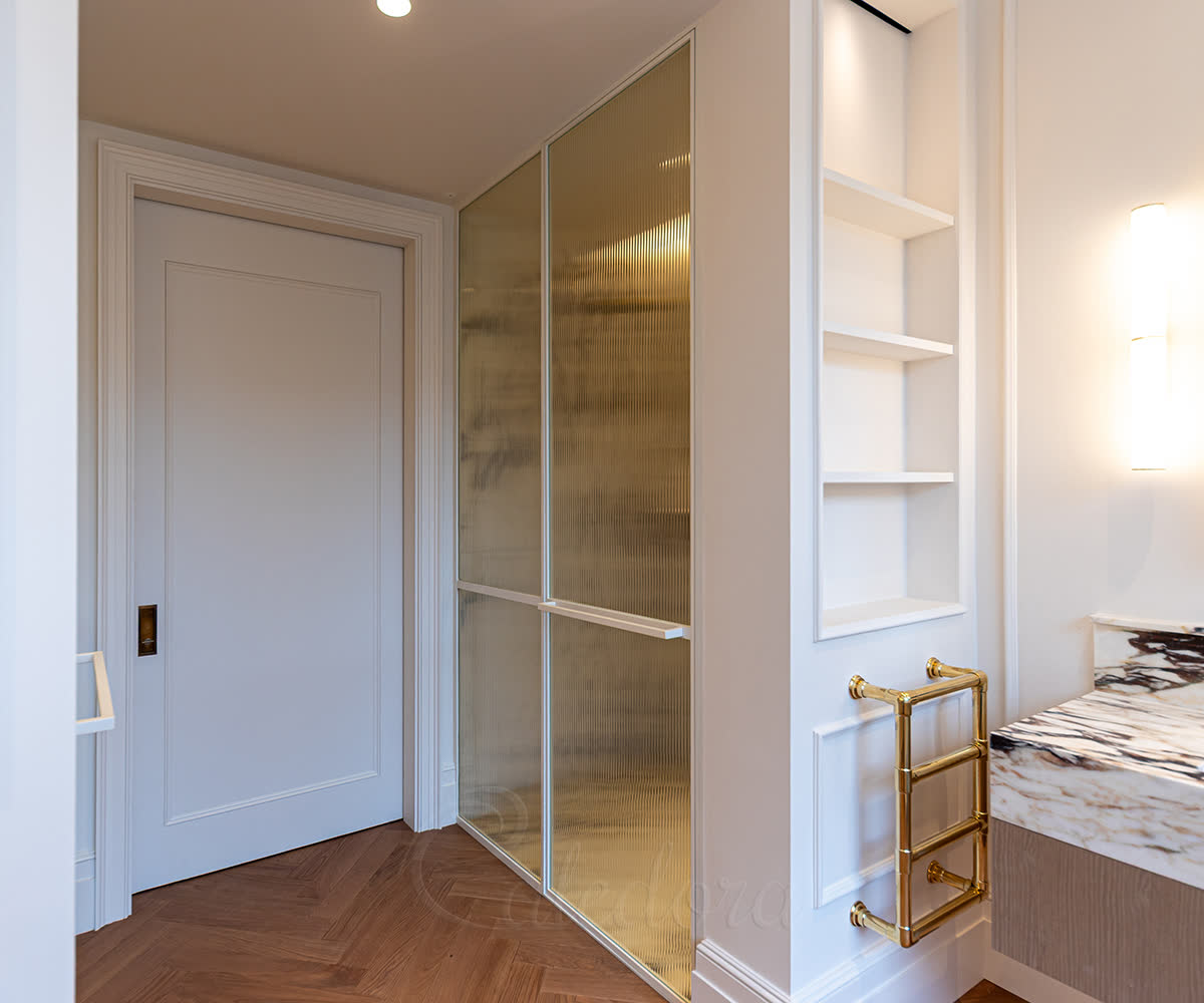 White powder-coated framed shower door with 4+4mm laminated reeded glass and horizontal divider bar in a London bathroom