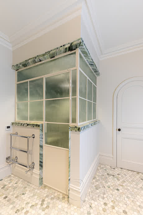 shower enclosure with reeded glass and white frame in crittall style