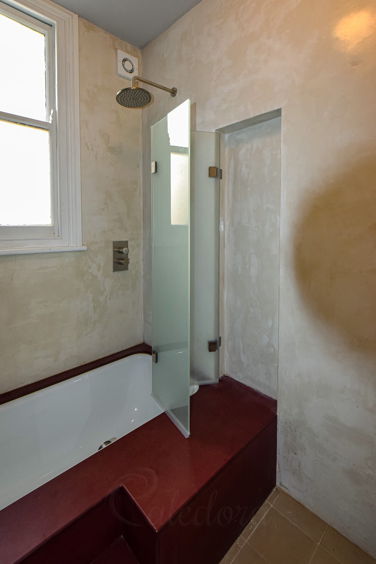 Frameless folding shower screen with frosted glass installed on a custom bath